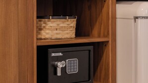 A wooden cabinet with a woven basket and a black safe. - B&B Stanze Guelfe (Florence)