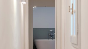 A narrow hallway leading to a bathroom with a bathtub and a shower. - B&B Stanze Guelfe (Florence)