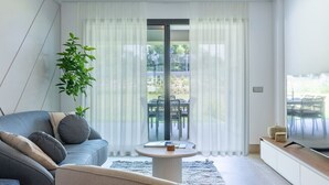 Ein modernes Wohnzimmer mit einer Couch, einem Sessel und einem runden Couchtisch.