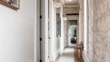 A hallway with a patterned rug, a chandelier, and a door labeled "The Vault".