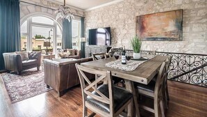 Un coin repas avec une table en bois, des chaises et un téléviseur fixé au mur.