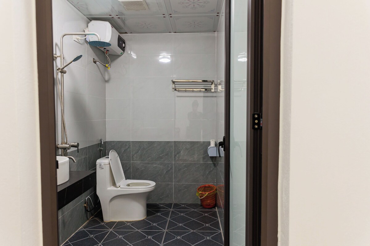 A small, modern bathroom with a toilet, sink, and shower.