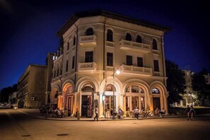 Un edificio histórico de estilo arquitectónico clásico, con ventanas de arco y una entrada central.