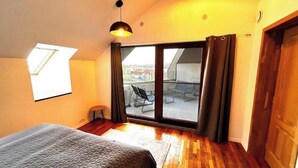 A bedroom with a large window, a bed, a chair, and a view of a balcony. - The Admiral / Luxury Apartment in Constanta (Unknown)