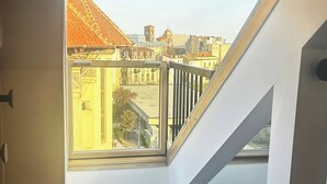 Une pièce avec un plafond en pente, une grande lucarne et un tapis en peau de vache sur le sol.