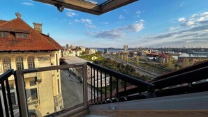 Un balcon offrant une vue sur le paysage urbain, avec des bâtiments et une rivière.