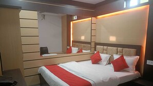 Una habitación de hotel con cama, escritorio y espejo.