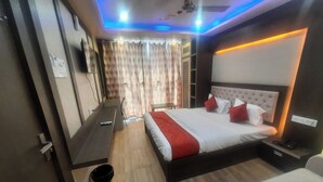 Una habitación de hotel moderna con una cama grande, un escritorio y un ventilador de techo.