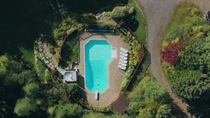 An aerial view of a swimming pool surrounded by lush greenery and a stone pathway. - DOMAINE BONHEURA; A HAVEN OF PEACE SURROUNDED BY NATURE IN ABUNDANCE! (Val-David)