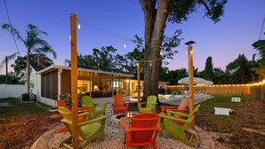 A backyard with a fire pit, outdoor seating, and a pool. - 5BR~Huge Backyard~Minigolf~Heated Pool~Outdoor Projector~Gameroom~FIOS WiFi (Brandon)