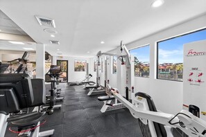A gym with cardio machines, free weights, and exercise equipment.
