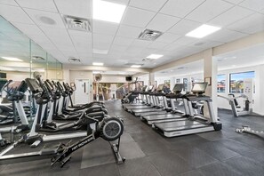 A gym with multiple treadmills and elliptical machines arranged in rows. - Edgewater Beach Resort Beachfront Sleeps 8 Golf (Panama City Beach)