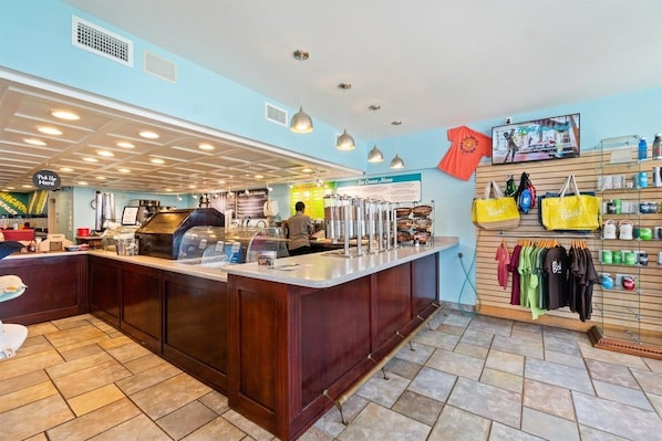 A bar area with a counter, seating, and a wall displaying various items.