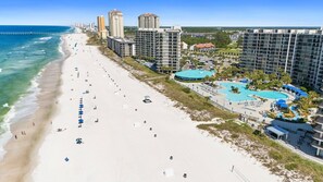 A beach resort with a swimming pool, beachfront, and high-rise buildings.