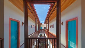 A corridor with wooden railings, turquoise doors, and a clear sky view. - CASA MANOA POUSADA (Maragogi)