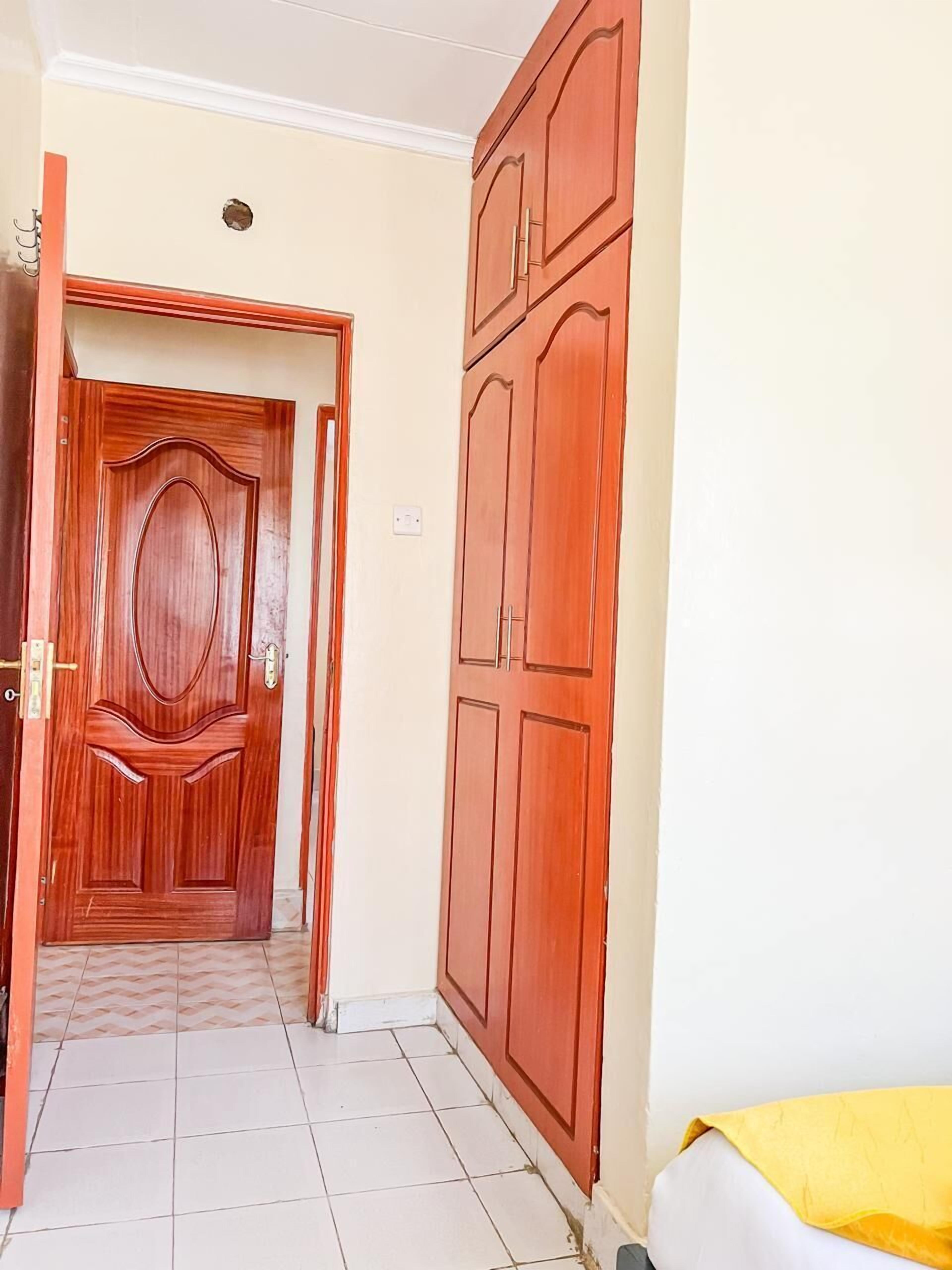 A hallway with a wooden door and a wardrobe.