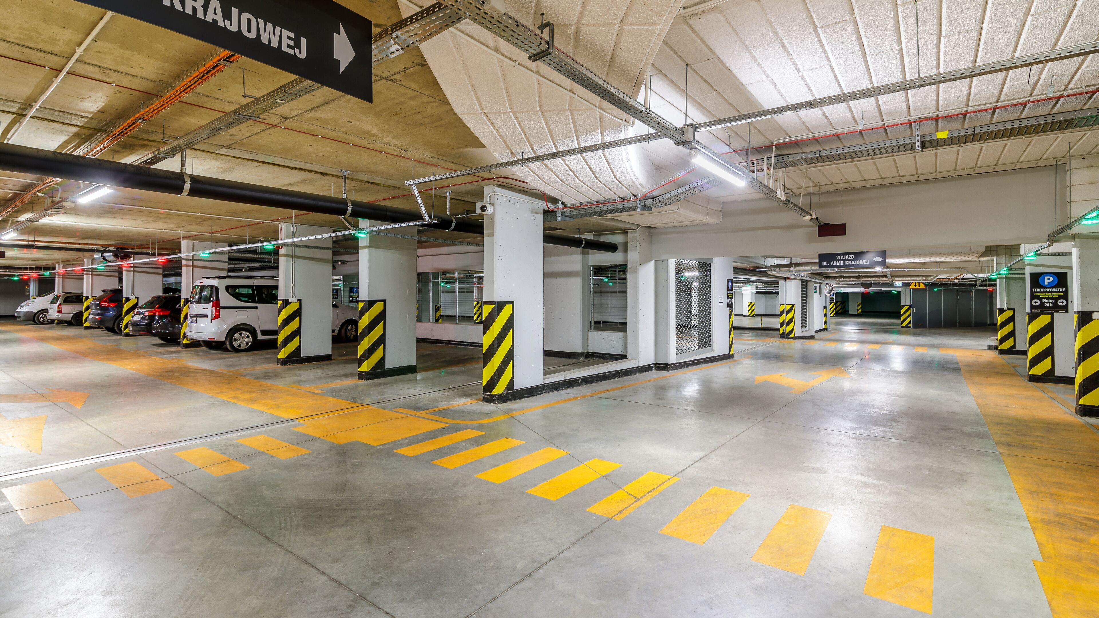 A multi-level parking garage with clear directional signage, multiple parking levels, and a clean, well-lit environment.