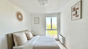 Un dormitorio con cama, ventana, radiador y decoración en la pared.