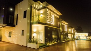 A modern two-story house with a well-lit entrance and a covered outdoor area.