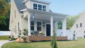 A two-story house with a covered porch, a well-maintained lawn, and a rock garden. - 3-bedroom bungalow in charming Easley with AC, WiFi (Easley)