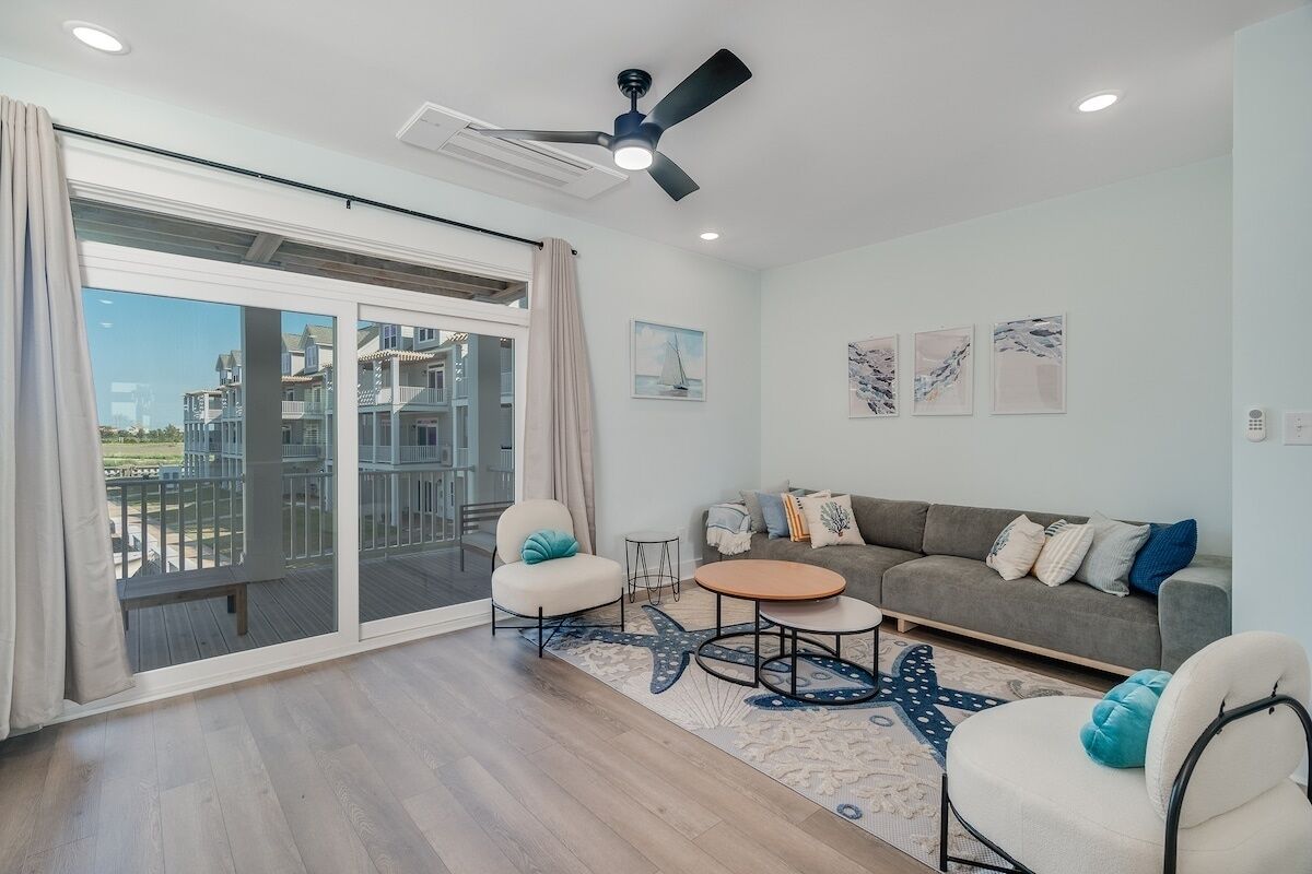 A modern living room with a sofa, two armchairs, a coffee table, and a starfish-patterned rug.