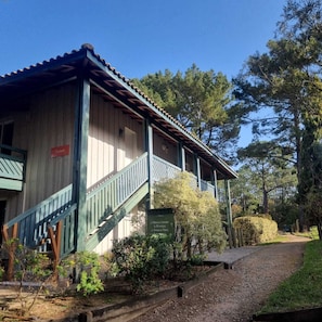 Un edificio in legno con una scala verde e un cartello che indica servizi come un campo da tennis e un'area per la bocce.