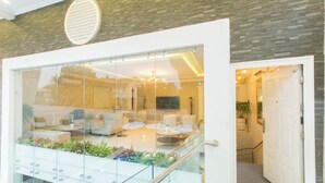 Ein modernes Interieur mit einer Glaskonstruktion, einer Treppe und einer Sitzecke mit Kissen.