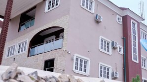 Ένα πολυώροφο κτίριο με πρόσοψη από πέτρα, πολλά παράθυρα και μπαλκόνια.