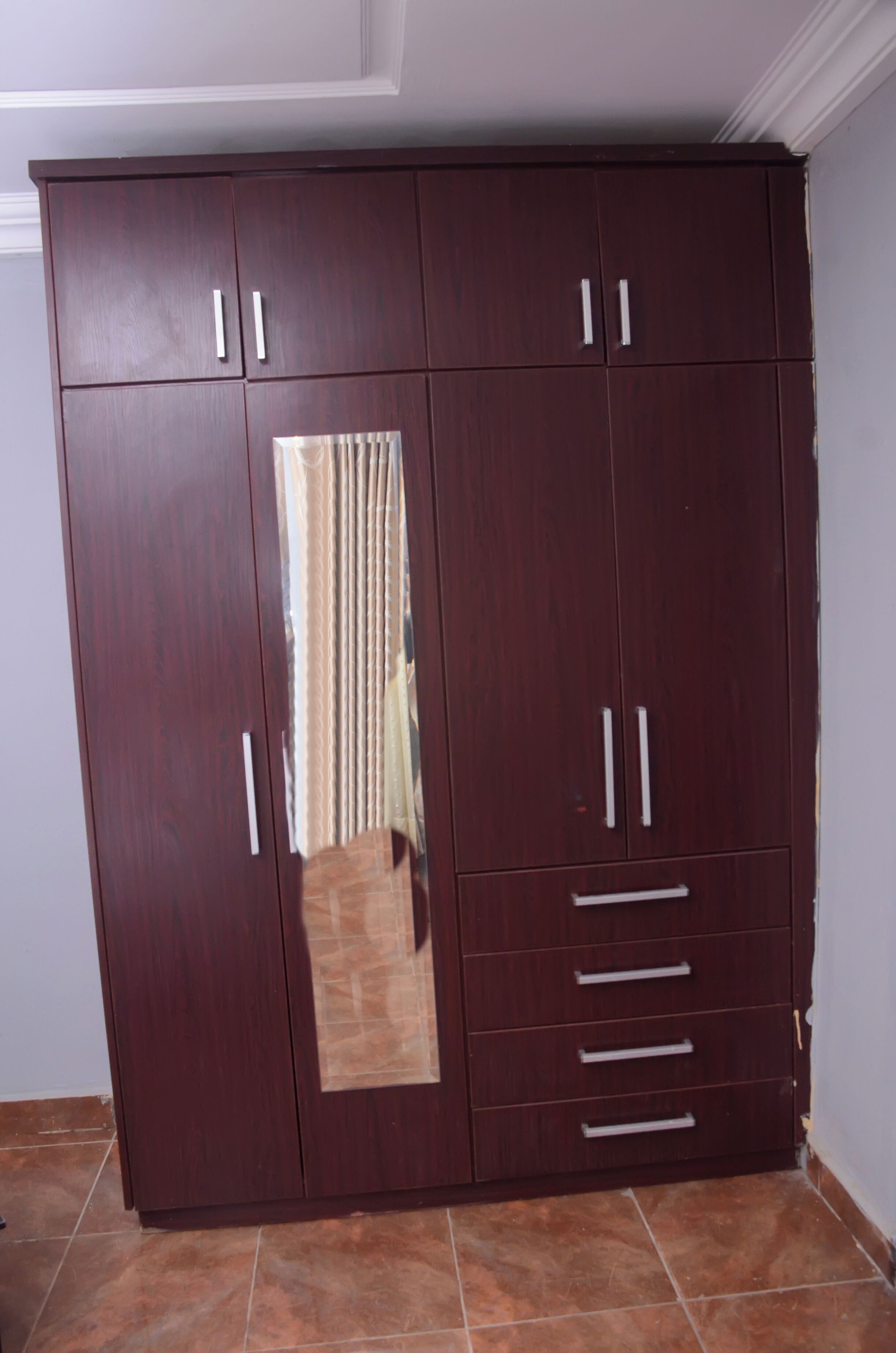 Un armario grande de madera con varias puertas y cajones.