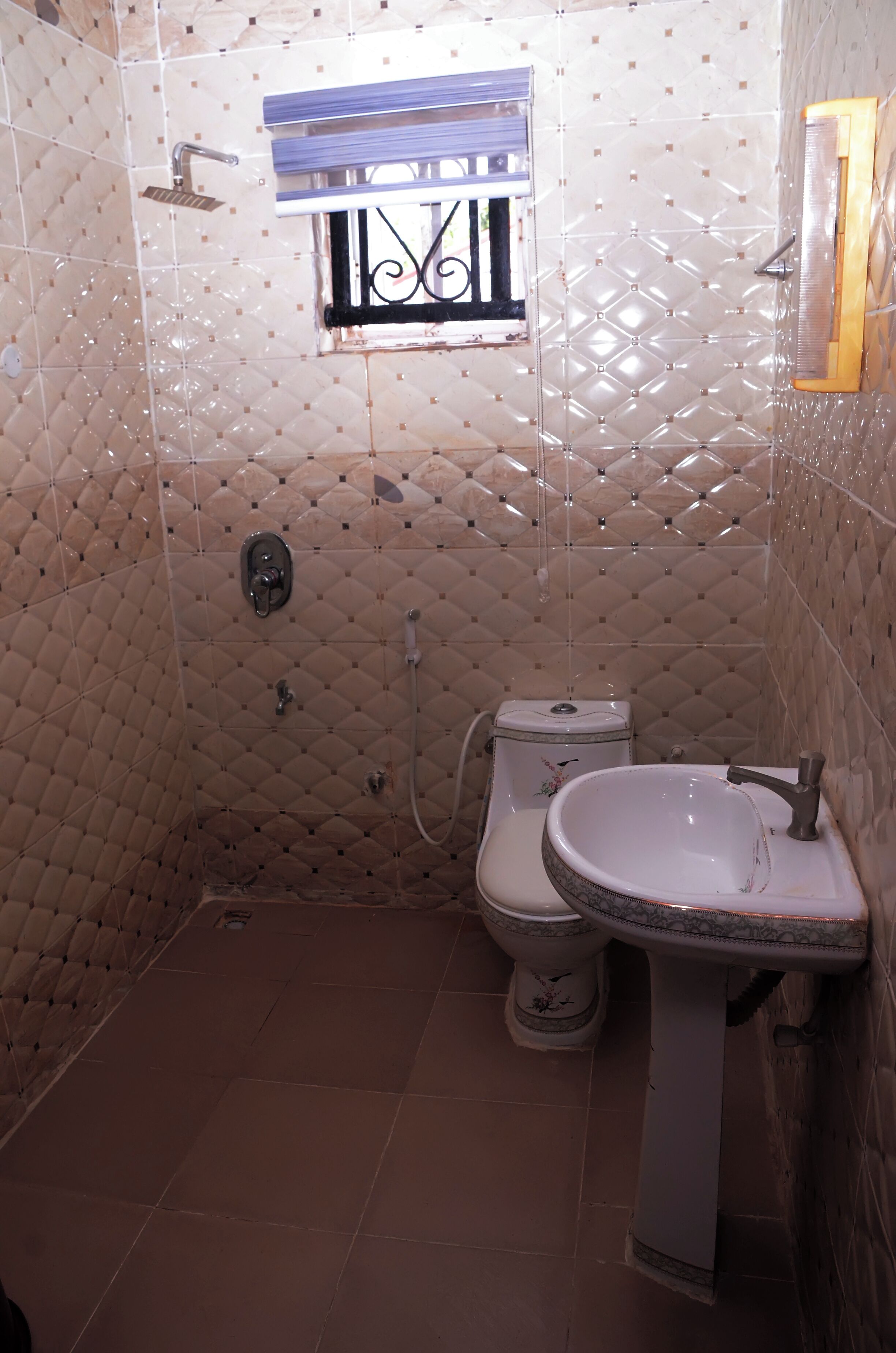 A bathroom with a toilet, sink, and shower.