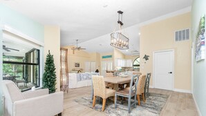 A spacious kitchen with a dining area, large windows, and a Christmas tree. - Island Oasis on Manasota Key- Steps to both Gulf & Bay Access, Heated Pool (Englewood)