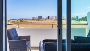 Un balcó amb mobiliari de vusta i vista a la ciutat.