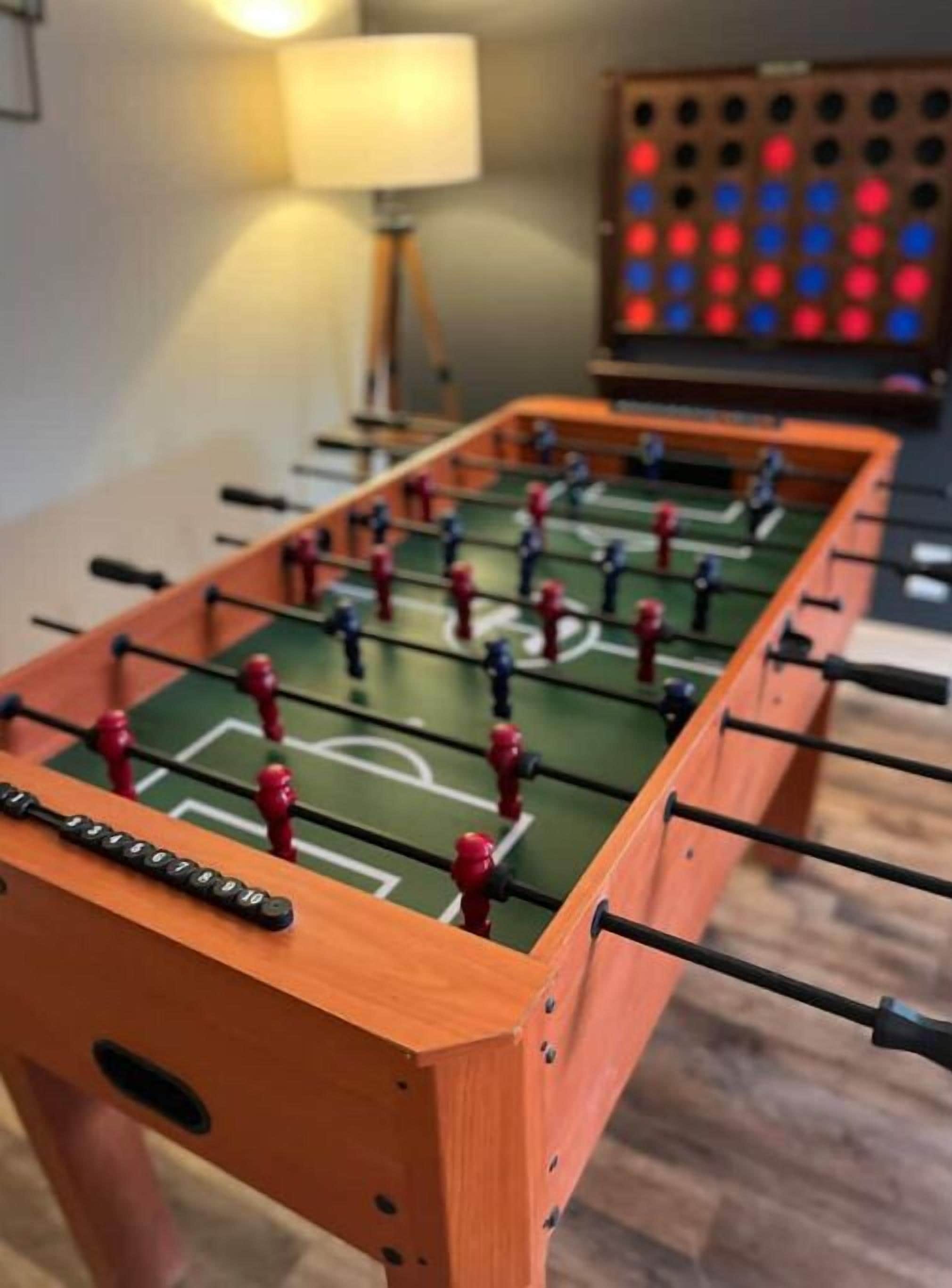 A foosball table with a green playing surface and red and blue player figures.