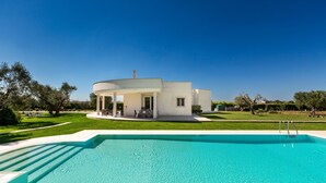 A modern house with a swimming pool in front.