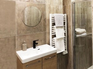 Een douche, een haardroger, handdoeken, toiletpapier