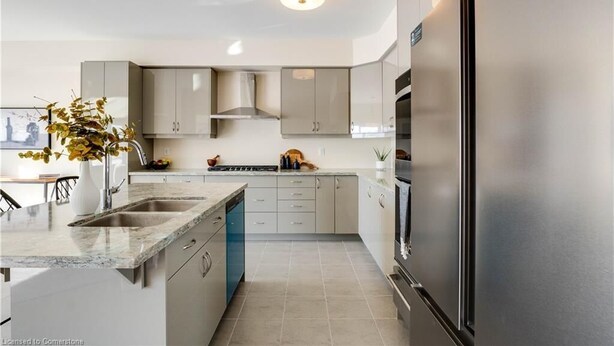 A modern kitchen with a stainless steel refrigerator, a built-in oven, and a central island with a sink. - Luxury 5BD 4BR Sleep 12 - Large Groups, Family, Events , Wedding near Brantford (Brant)