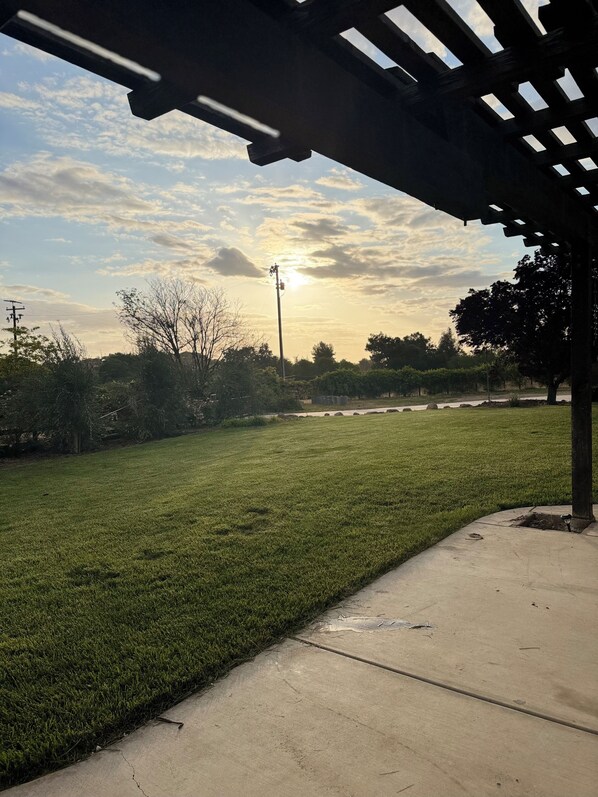 A grassy area with a concrete path and a pergola structure. - Large Groups 4-Bedroom, 2-Bath Paso Robles Retreat on Eastside Near Top Wineries (Paso Robles)