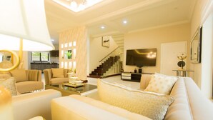 A modern living room with a sofa, coffee table, and a TV mounted on the wall.