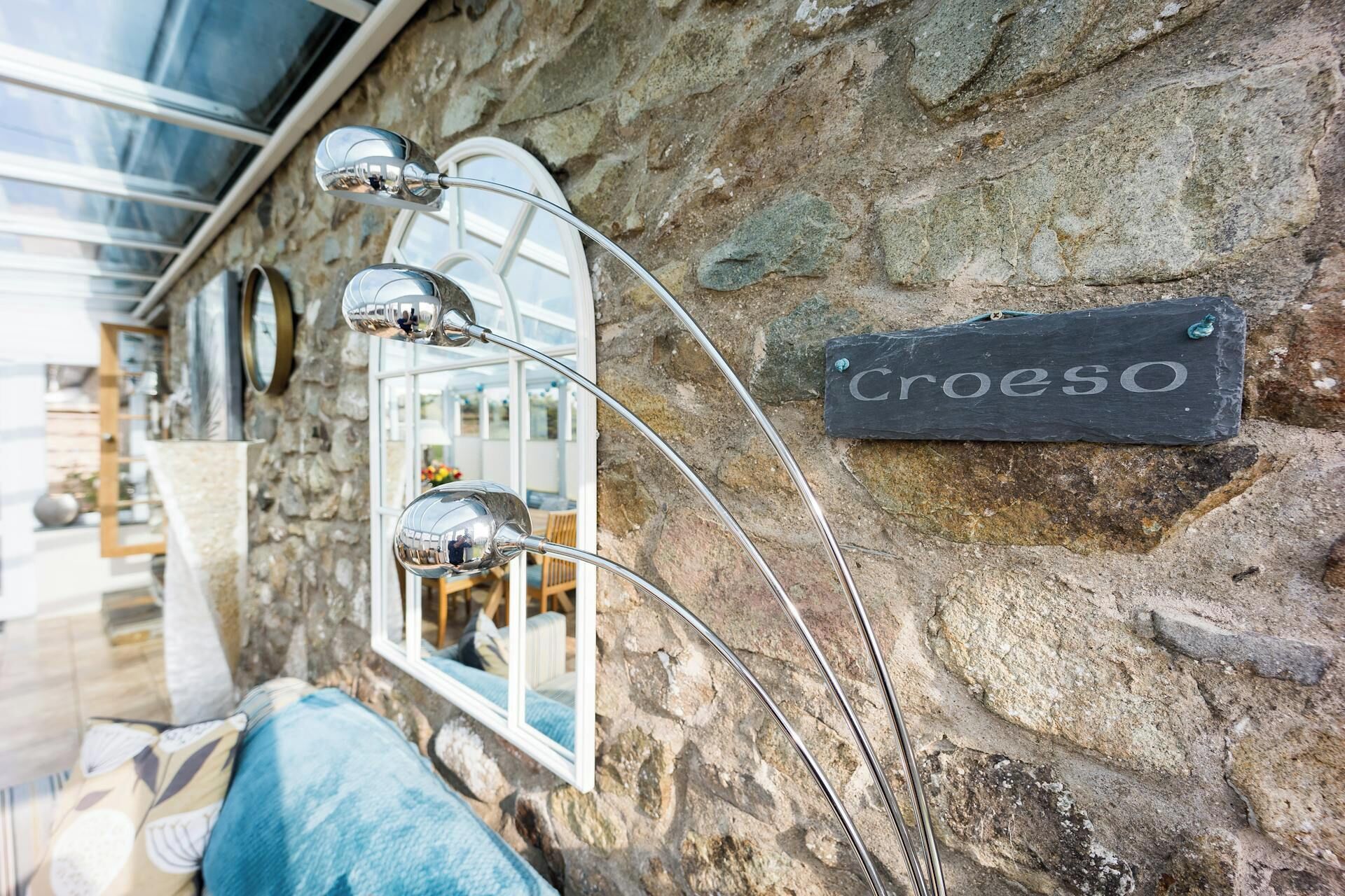 A stone wall with a sign reading 'Croeso' and a metal lamp post.