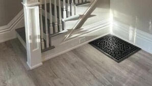 A staircase with white balusters and a handrail, leading to a landing with a black doormat. - Just remodeled, for you! (Grand Rapids)