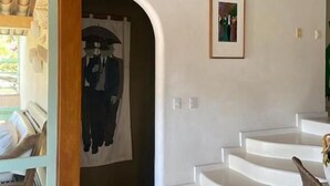 A modern interior with a curved staircase, a wooden ceiling, and a framed picture on the wall. - Casa 24 Búzios (Buzios)