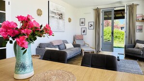 A modern living room with a sofa, armchairs, a coffee table, and a vase of flowers. - Charming cottage with pool, air-Con, views & high speed WiFi (La Sauvetat-du-Dropt)