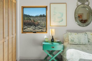 A bedroom with a bed, a nightstand with a lamp, a framed picture, and a mirror on the wall. - 25 Acre Artist Ranch, hot tub & tennis, near Aspen (Carbondale)