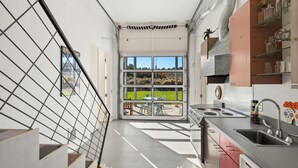 A modern kitchen with a large window, a staircase, and a view of a garden. - 25 Acre Artist Ranch, hot tub & tennis, near Aspen (Carbondale)