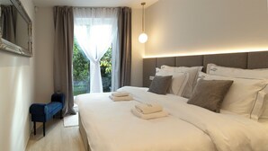 Ein Hotelzimmer mit einem großen Bett, einem Nachttisch, einer Bank und Blick auf Grün.