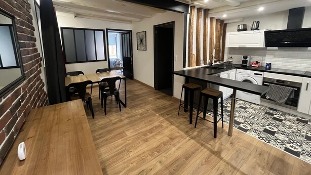 A modern kitchen with a central island, wooden flooring, and a dining area with chairs. - Apartment rental Limoges (Limoges)