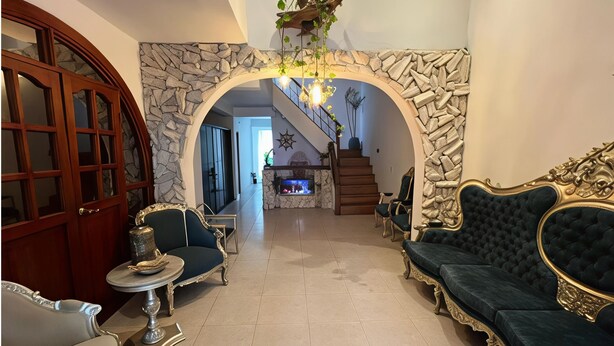 A spacious living area with a stone archway, elegant furniture, and a staircase leading to an upper level. -  Hotel Tierra y Mar Boutique (Cartagena)
