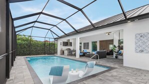 Ein Swimmingpool mit Liegestühlen und einer überdachten Terrassenfläche.