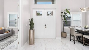 Ein modernes Interieur mit Essbereich, einer Couch und einer großen Pflanze.