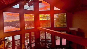 A room with large windows, a wooden ceiling, and a view of a landscape. - Lake Cabin 8 acres private dock fire pit hot tub game room (Gouverneur)
